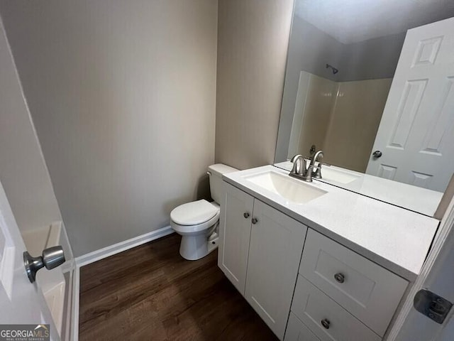 full bathroom with wood finished floors, a shower, toilet, vanity, and baseboards