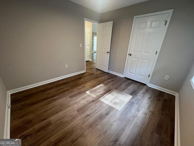 unfurnished bedroom featuring dark wood-style floors and baseboards