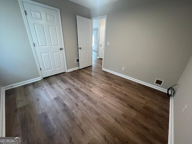 unfurnished bedroom featuring baseboards and dark wood finished floors