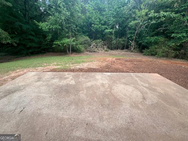view of yard with a patio and a view of trees