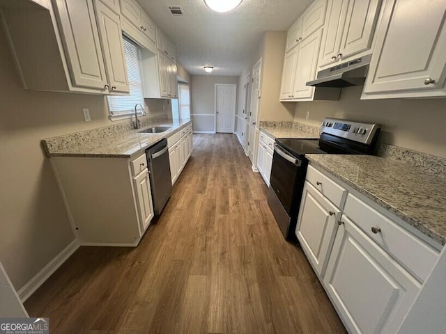 kitchen with appliances with stainless steel finishes, a sink, under cabinet range hood, dark wood finished floors, and white cabinets