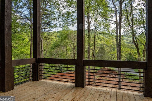 wooden terrace featuring a wooded view