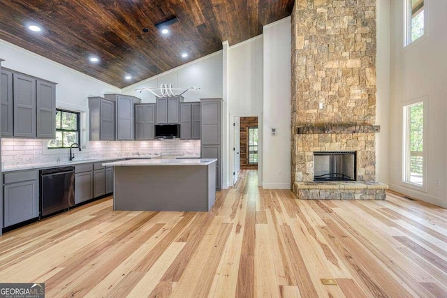 kitchen with dishwasher, gray cabinetry, wood ceiling, a stone fireplace, and high vaulted ceiling