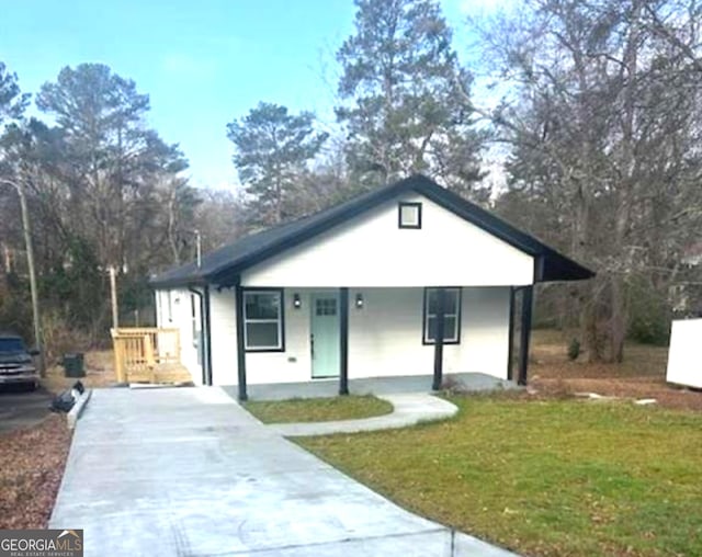 view of front of house featuring a porch, driveway, and a front lawn