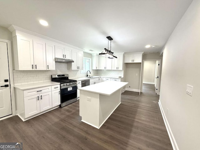 6205 Hudson St NW, Covington, GA 30014 - kitchen featuring stainless steel appliances, under cabinet range hood, tasteful backsplash, white cabinetry, and light countertops