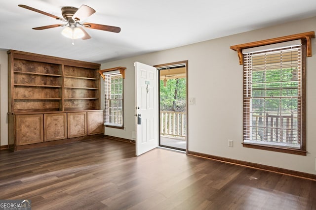 empty room featuring dark wood-style flooring, ceiling fan, and baseboards
