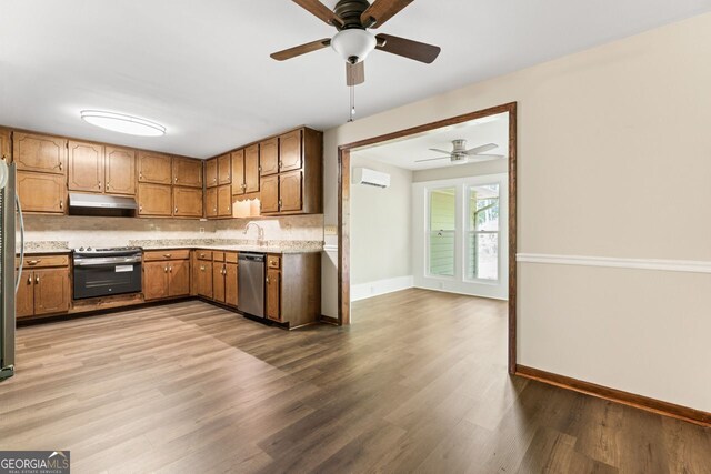 kitchen featuring stainless steel appliances, under cabinet range hood, ceiling fan, light wood-type flooring, and light countertops