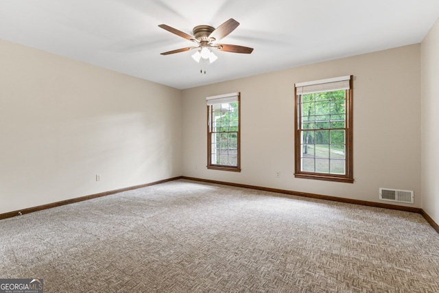 carpeted spare room with baseboards and ceiling fan