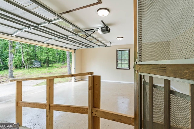 garage featuring a garage door opener and baseboards