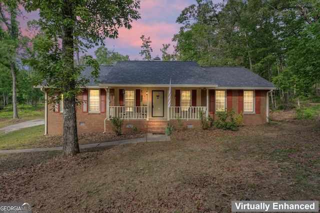 ranch-style house featuring a porch, crawl space, brick siding, a front yard, and roof with shingles