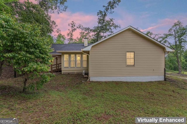 368 Henry Higgins Rd, Jackson, GA 30233 - back of house at dusk with a lawn, a chimney, and a sunroom