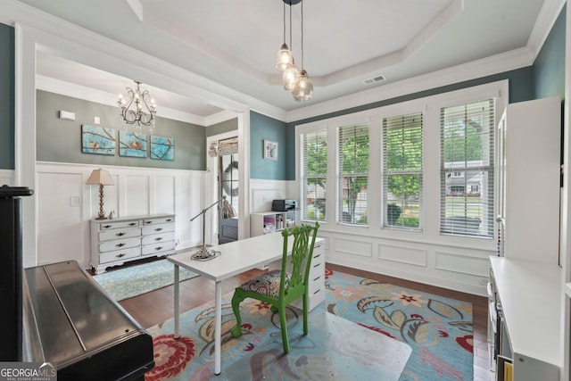 office area with dark wood-style flooring, a chandelier, a decorative wall, a wainscoted wall, and crown molding