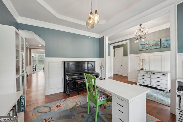 home office featuring a chandelier, a decorative wall, crown molding, dark wood finished floors, and wainscoting