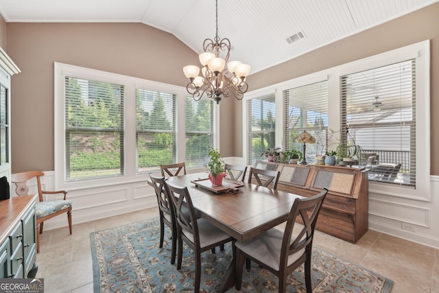 dining room with a decorative wall, vaulted ceiling, wainscoting, a chandelier, and light tile patterned flooring