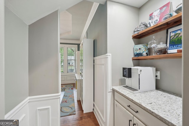 laundry room with dark wood finished floors and crown molding