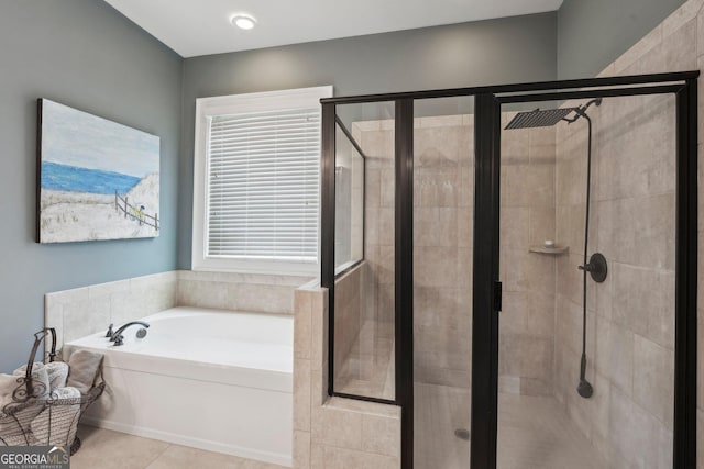 bathroom featuring a shower stall, a garden tub, and tile patterned floors