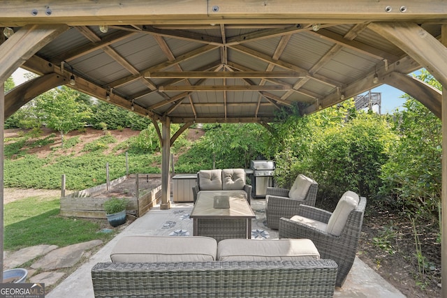 view of patio with a gazebo, a vegetable garden, outdoor lounge area, and a grill