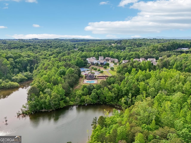 drone / aerial view of a heavily wooded area and a nearby body of water