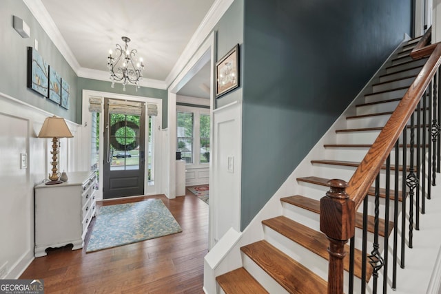 entryway featuring a chandelier, stairway, crown molding, and wood finished floors