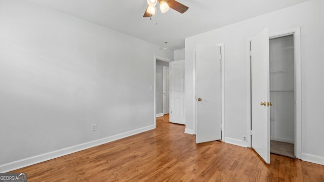 19 Fernwood Way NE, Rome, GA 30161 - unfurnished bedroom featuring baseboards, light wood-style floors, a closet, a ceiling fan, and a walk in closet