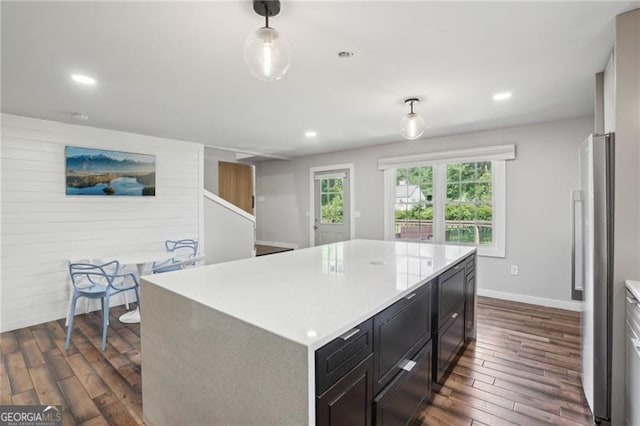 kitchen featuring dark wood-type flooring, freestanding refrigerator, light countertops, baseboards, and recessed lighting