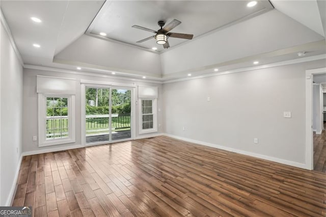 spare room featuring ceiling fan, ornamental molding, baseboards, wood finished floors, and a raised ceiling