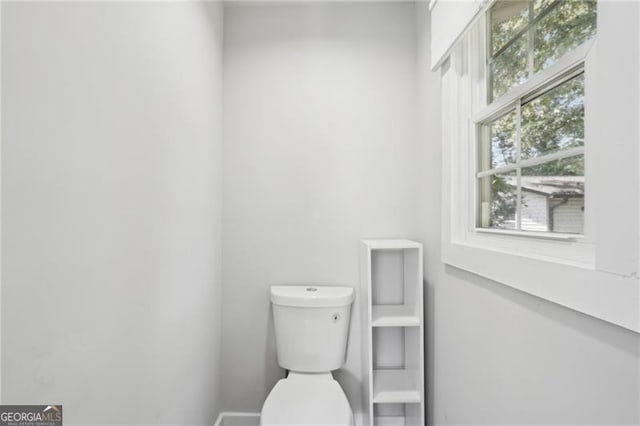 bathroom with toilet and baseboards