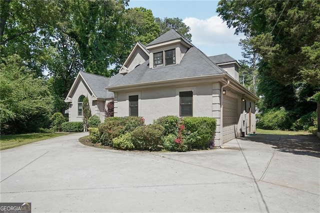view of home's exterior with driveway, a garage, and stucco siding