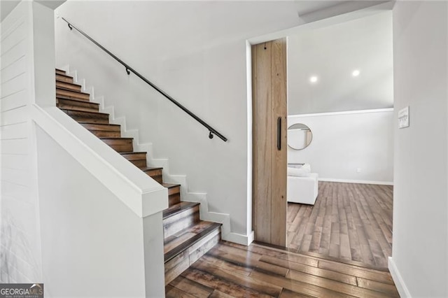 staircase with wood finished floors, baseboards, and recessed lighting