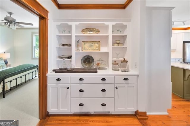bar with ceiling fan, freestanding refrigerator, light wood-style flooring, ornamental molding, and gas cooktop