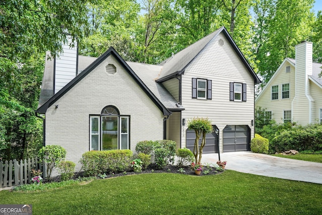 view of front facade featuring an attached garage, a chimney, concrete driveway, brick siding, and roof with shingles