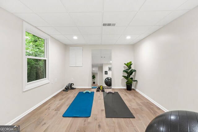 workout area featuring wood finished floors, a drop ceiling, baseboards, and recessed lighting