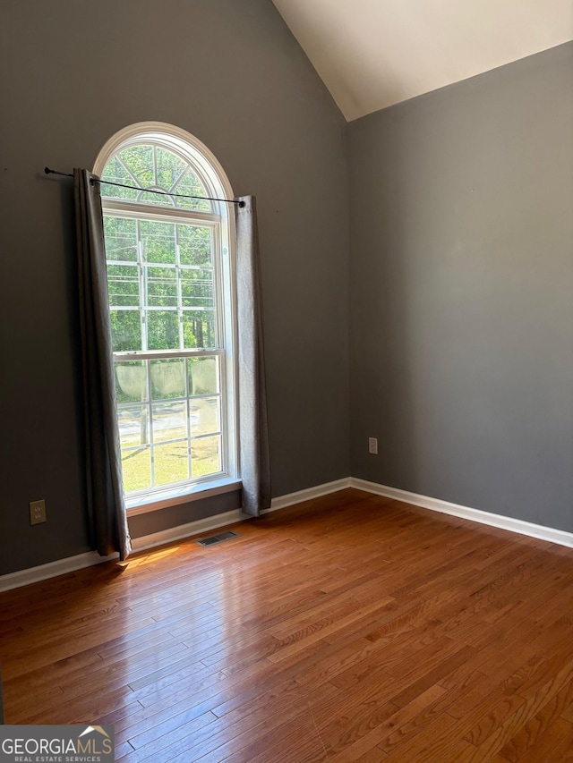 2828 Hicks Rd SW, Marietta, GA 30060 - empty room with wood finished floors, lofted ceiling, and baseboards