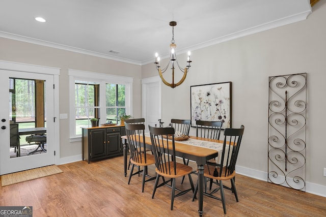 dining room featuring a chandelier, light wood-style floors, crown molding, and baseboards