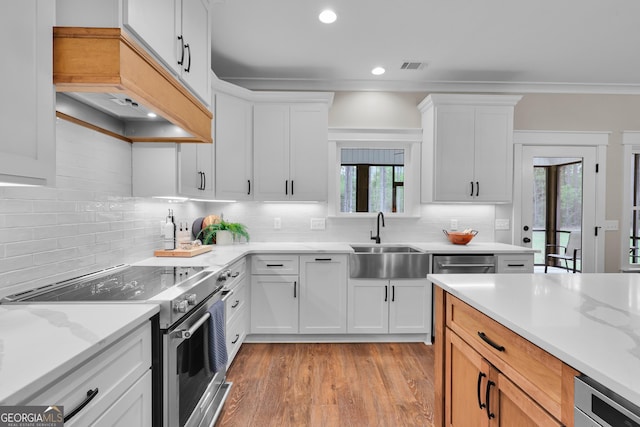 kitchen with stainless steel electric stove, a sink, light wood-style floors, tasteful backsplash, and recessed lighting
