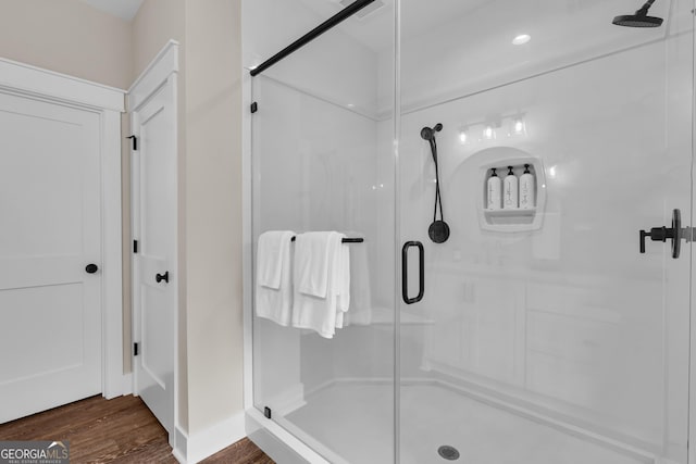 full bathroom featuring a shower stall and wood finished floors