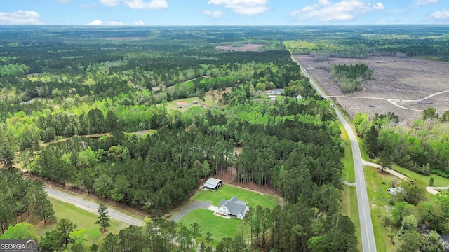 aerial view of property and surrounding area with a heavily wooded area