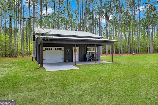 rear view of house with board and batten siding, a lawn, and a garage