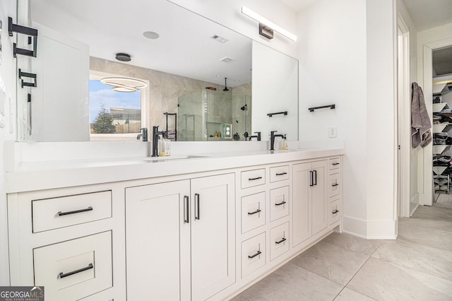 full bath featuring a stall shower, double vanity, baseboards, and a spacious closet