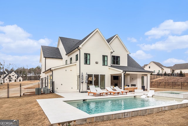 rear view of property with a jacuzzi, a patio area, a fenced backyard, and an outdoor living space