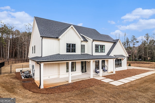 view of front of property with a shingled roof and fence