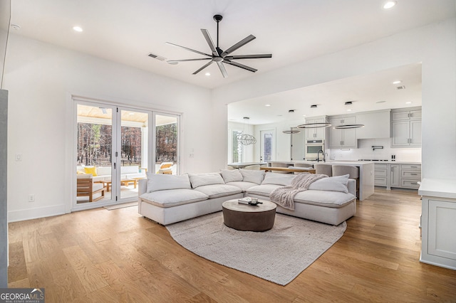 living room with ceiling fan, light wood-style floors, and recessed lighting