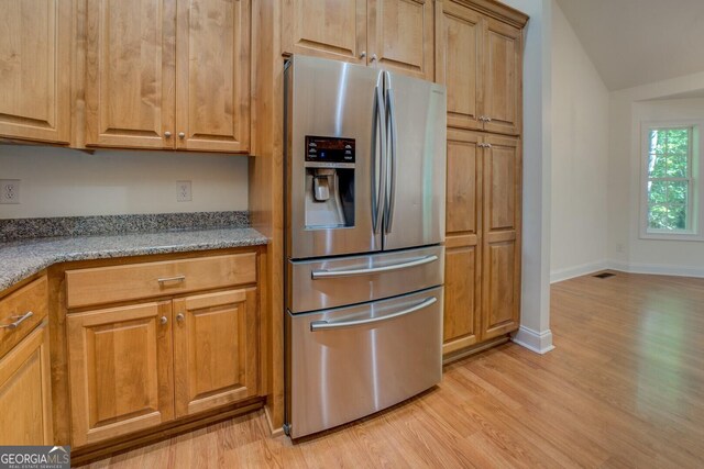 349 Bowen Hill Rd, Haddock, GA 31033 - kitchen featuring stainless steel refrigerator with ice dispenser, light wood-type flooring, baseboards, and brown cabinetry