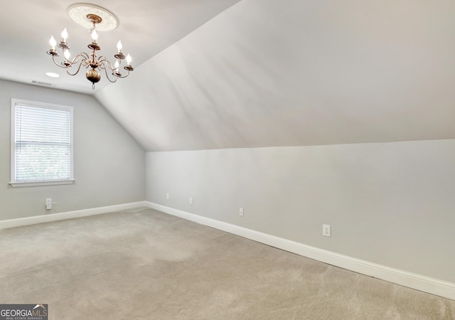 additional living space with a chandelier, baseboards, vaulted ceiling, and light carpet