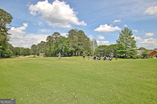 view of home's community featuring a yard and view of wooded area