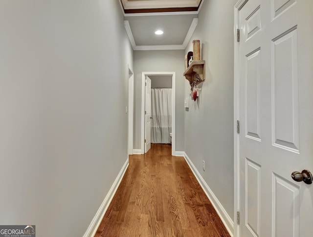 corridor featuring ornamental molding, wood finished floors, and baseboards