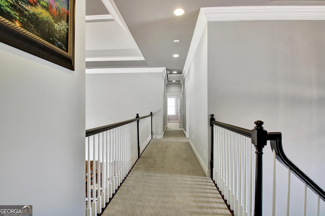 hallway featuring carpet floors, recessed lighting, ornamental molding, baseboards, and an upstairs landing