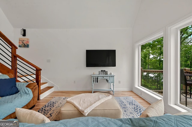 living area featuring stairs, light wood-style floors, and baseboards