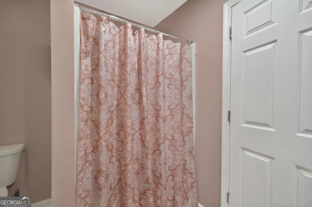 full bath with toilet, baseboards, and curtained shower