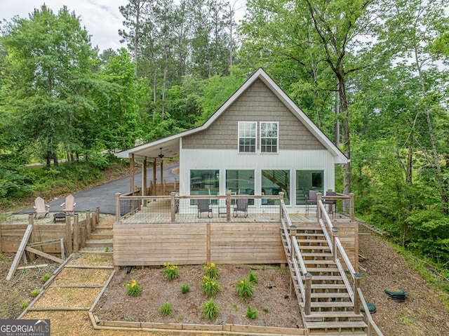 view of front of home featuring stairway, a wooden deck, and fence